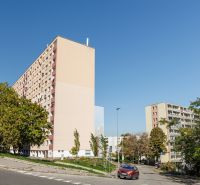 Wohnhäuser in der Adámiho-Straße in Bratislava - Karlova Ves, umgeben von Grünflächen und einer Straße.