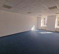 Helles, geräumiges Büro mit blauem Teppichboden und weißen Wänden.