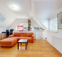 Helles Wohnzimmer mit orangefarbenem Sofa, Arbeitsecke und Boden in Holzoptik.