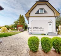Ein Einfamilienhaus in der Hauptstraße in Miloslavov mit gepflegtem Garten und gepflasterter Zufahrtsstraße.