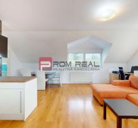 Wohnzimmer mit orangem Sofa, Schreibtisch und Holzboden in einer 2-Zimmer-Wohnung.