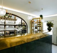 Innenraum von Geschäftsräumen mit glänzender Bar, hängenden Gläsern und dekorativer Beleuchtung.