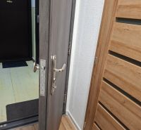 Eingangstür mit Metallbeschlägen in einer Einzimmerwohnung, Boden mit Holzdekor.