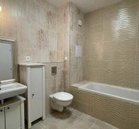 Badezimmer in einer 2-Zimmer-Wohnung mit Badewanne, Waschbecken, Schrank und Toilette.