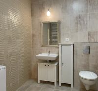 Badezimmer in einer 2-Zimmer-Wohnung mit Fliesen und weißen Sanitäreinrichtungen.
