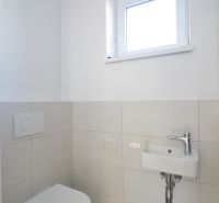 Toilette mit Waschbecken in einer 3-Zimmer-Wohnung, einfaches weißes und graues Farbschema.