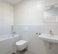 Badezimmer in einer 3-Zimmer-Wohnung mit Badewanne, Toilette und Waschbecken, Fliesen in beige.