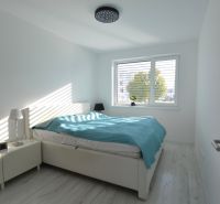 Ein Schlafzimmer mit weißen Möbeln und einer türkisfarbenen Decke in einer 3-Zimmer-Wohnung.