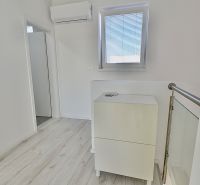 Ein heller Flur in einer 3-Zimmer-Wohnung mit Klimaanlage und einem Boden in Holzoptik.