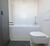 Badezimmer mit Badewanne und hängendem WC in einer 3-Zimmer-Wohnung. Minimalistisches Design.