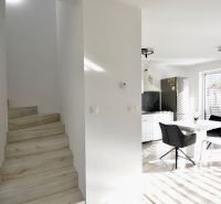 Innenraum einer 3-Zimmer-Wohnung mit Essecke, Küche und Treppe mit Holzdekor.