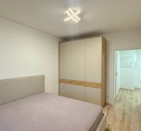 Helles Schlafzimmer mit Bett und Einbauschrank in einer 2-Zimmer-Wohnung.