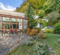 Ein Einfamilienhaus in der Karpatská-Straße in Marianka mit einem verglasten Wintergarten und einem gepflegten Garten.
