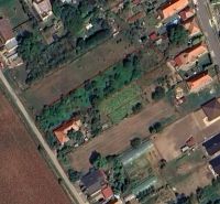 Grundstücke für Wohnzwecke in Jasová mit markiertem Gebiet, umgeben von Grünflächen und Gebäuden.
