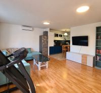 Wohnzimmer in einem Einfamilienhaus mit Holzboden, Sofa und Fernseher.