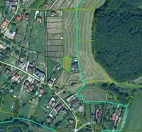 Luftaufnahme von Wohnbaugrundstücken in der Gemeinde Podzámčok, umgeben von Grünflächen und Parzellen.