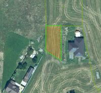 Grundstücke für Wohnzwecke in Podzámčok mit Umgebung von Häusern und landwirtschaftlichen Flächen.