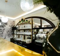 Obchodsräume mit einer Bar, Regalen mit Gläsern und einer Kaffeemaschine.