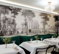 Ein Restaurant mit historischer Tapete, Kristallleuchter und grünen Sitzbänken in Geschäftsräumen.