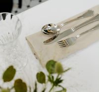 Ein gedeckter Tisch mit Besteck und Glas, dekoriert mit Blumen auf dem Tisch.