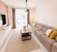 Helles Wohnzimmer in einer 2-Zimmer-Wohnung mit einem bequemen Sofa und Fenstern.
