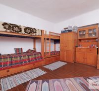Innenraum eines Einfamilienhauses mit einem Etagenbett, Kommoden und einem Boden mit Holzdekor.
