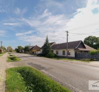 Einfamilienhäuser in der Hauptstraße in Štefanová mit gepflegtem Garten und klarem Himmel.
