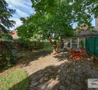 Im Garten des Einfamilienhauses in der Hauptstraße in Štefanová gibt es eine Sitzgelegenheit unter einem ausladenden Baum.
