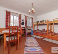 In einem Einfamilienhaus gibt es ein Etagenbett, einen Tisch und einen Boden mit Holzdekor.