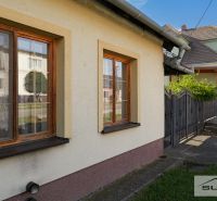 Ein Einfamilienhaus in der Hauptstraße in Štefanová mit braunen Fenstern und einem grünen Rasen.