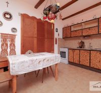 Eine Küche in einem Einfamilienhaus mit rustikalem Dekor und Wanddekorationen über dem Tisch.