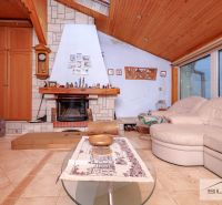 Wohnzimmer mit Kamin und Sofa in einem Einfamilienhaus, Boden mit Holzdekor.