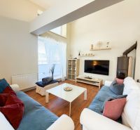 Wohnzimmer in einer 3-Zimmer-Wohnung mit Holzboden, bequeme Sofas, Fernseher.