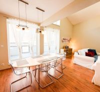 Wohnzimmer mit großen Fenstern, Sofas und Holzboden in einer 3-Zimmer-Wohnung.
