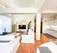 Wohnzimmer mit Holzdekorboden in einer 3-Zimmer-Wohnung, helle Einrichtung, Küchenzeile.
