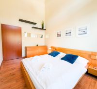 Schlafzimmer mit Holzboden, Bett, Kommode und Dekorationen in einer 3-Zimmer-Wohnung.