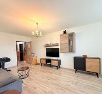 Wohnzimmer in einer 3-Zimmer-Wohnung mit Holzboden und Möbeln.