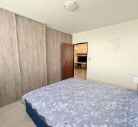 Schlafzimmer mit Bett, Einbauschrank und Durchgang zum Wohnzimmer in einer 3-Zimmer-Wohnung.