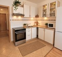 Küche mit weißen Schränken und Geräten in einer 2-Zimmer-Wohnung.