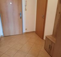Eingangsflur in einer 2-Zimmer-Wohnung mit Fliesenboden und Holztüren.