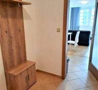 Diele in einer 2-Zimmer-Wohnung mit einer Garderobenwand und Blick ins Wohnzimmer mit Essbereich.