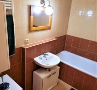 Badezimmer mit Waschbecken, Badewanne und Schrank in einer 2-Zimmer-Wohnung.