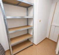 Úložný Raum in einer 2-Zimmer-Wohnung mit einem Metallregal und Fliesenboden.
