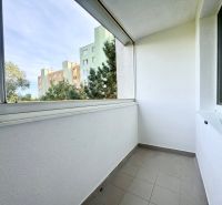 Ein Balkon mit Fliesenboden in einer 3-Zimmer-Wohnung mit Blick auf die umliegende Grünfläche.