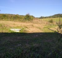 Landschaft in Horná Breznica bei der Hütte, eine Wiese umgeben von Natur und einem Zaun.