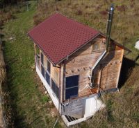 Eine Hütte in Horna Breznica am Hang mit Holzverkleidung und Solarmodulen.