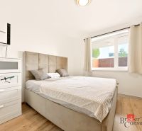 Schlafzimmer in einer 2-Zimmer-Wohnung mit Bett und Schrank, Boden mit Holzdekor.