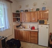 Küche mit Holzschränken, Mikrowelle und Kühlschrank, Grundstücke - Wohnen.