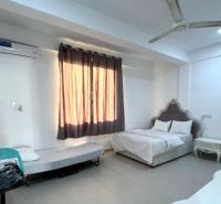 Ein Zimmer mit Bett, Tisch und Sofa in einer 2-Zimmer-Wohnung.
