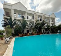 Gebäude am Pool und Palmen im Stadtteil Mbweni in Sansibar.